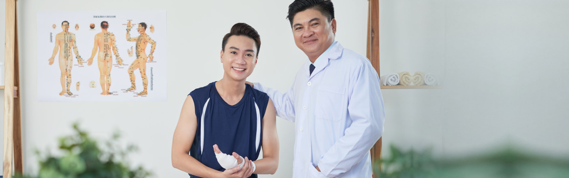 doctor and his patient with bandage on hand smiling