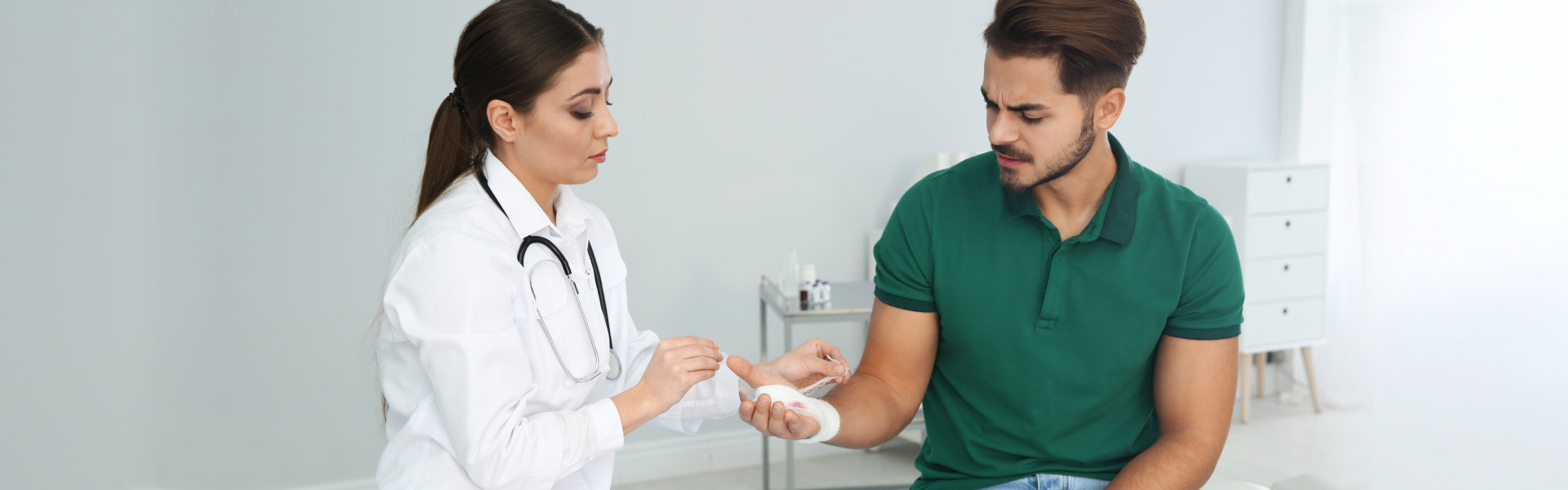 nurse bandaging her patients wound